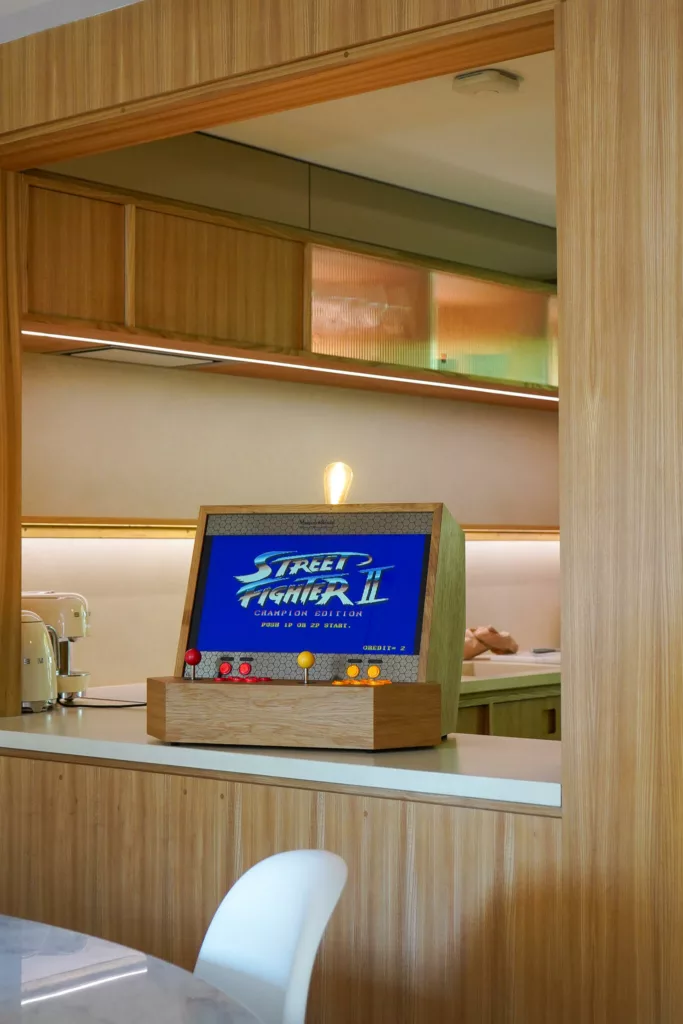 Meuble d'arcade de luxe en bois avec jeu d'arcade Street Fighter dans une cuisine en bois