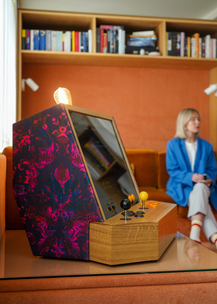 Arcade cabinet with pink fabric in 70s space age style living room