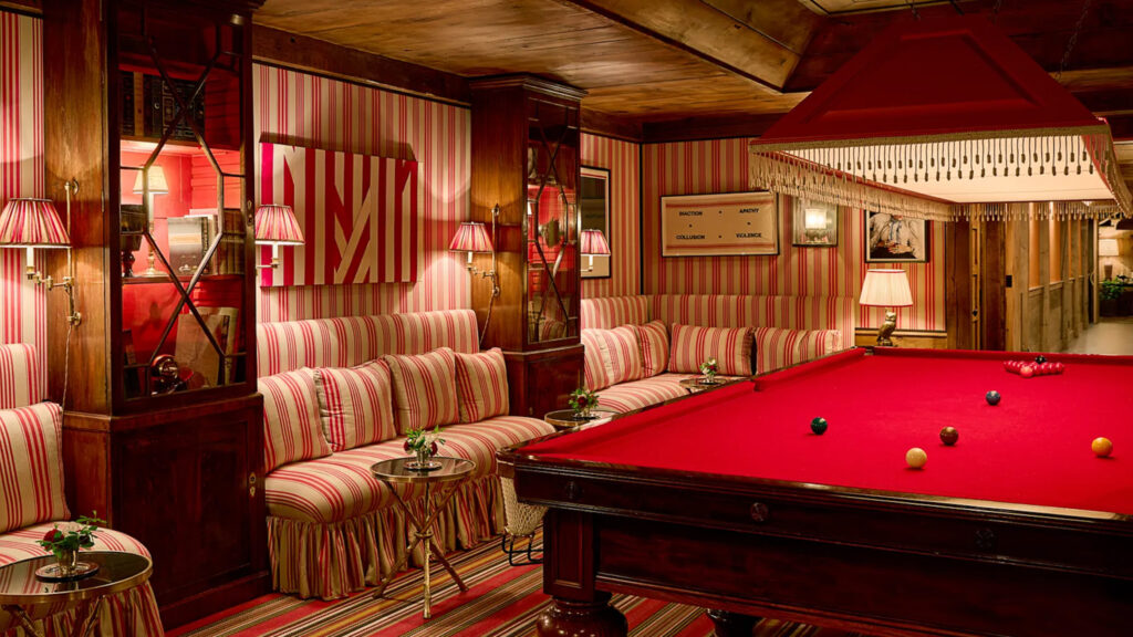 Moody red and white games room with pool table and lounge space