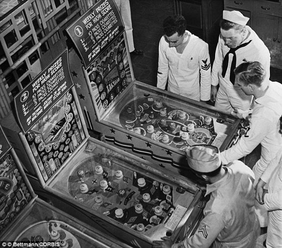 Game hall with sailors playing on pinball machines